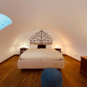 een slaapkamer met een bed met een hoofdeinde en 2 tafels bij Mariuccia House in Amalfi