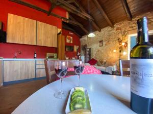 a bottle of wine and two wine glasses on a table at Platanus Apartment in Vanáton