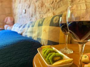 un piatto di frutta e un bicchiere di vino su un tavolo di Platanus Apartment a Vanáton