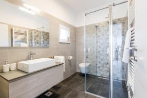 Modern 3-bedroom villa with a private pool في بولا: حمام مع حوض ودش