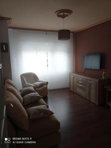a living room with a couch and a flat screen tv at Piso centrico en Pravia, con 3 habitaciones sin ascensor in Pravia