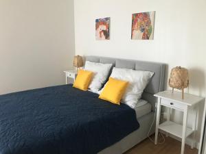 sypialnia z niebieskim łóżkiem z żółtymi poduszkami w obiekcie Apartament w sercu Gdyni w mieście Gdynia