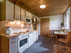 a kitchen with white appliances and a dining table at Freihof in Westendorf