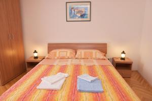 a bedroom with a bed with two towels on it at Apartment Anamarija Valun in Valun