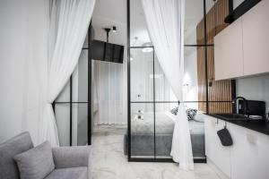 a bathroom with a glass shower and a bed at Old Town Design Apartments in Sarajevo