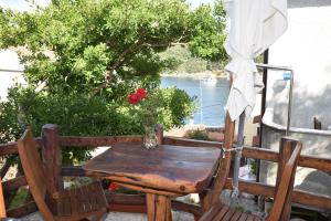 a wooden table and chairs on a balcony with a tree at Apartment Anamarija Valun in Valun +30 photos