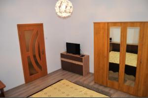a room with a bed and a mirror and a door at Pensiunea Happy Flowers in Greci