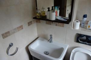 a bathroom with a white sink and a mirror at NEW Cosy 2 Bedroom Flat - Englefield Green in Englefield Green