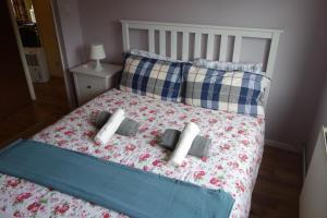 a bed with two pillows and two towels on it at NEW Cosy 2 Bedroom Flat - Englefield Green in Englefield Green