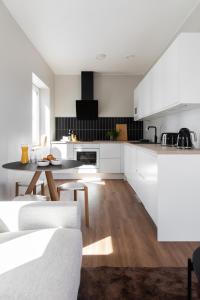 a kitchen with white cabinets and a table at Bucco Suites in Pori