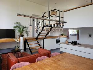 una cucina e un soggiorno con tavolo e scala di Mille Fleurs - apartments a Voeren