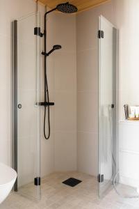 a shower with a glass door in a bathroom at Bucco Suites in Pori
