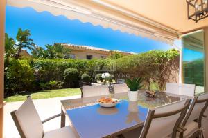 a dining table with a bowl of fruit on it at Spacious perfectly maintained house with private garden and communal pool in Riviera del Sol in Málaga