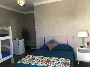 um quarto com uma cama com um cobertor colorido em Suíte Luxo Refúgio das Ostras no Guarujá