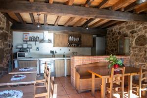 a kitchen and dining room with a table and chairs at Aldea Rural Santo André in Congostro