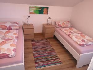 アインリングにあるFerienwohnung Alpenblickのベッド2台とナイトスタンドが備わる客室です。