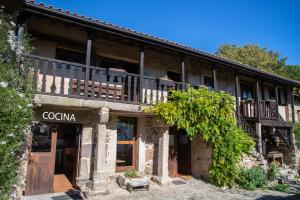 an old stone building with a porch and balcony at Aldea Rural Santo André in Congostro