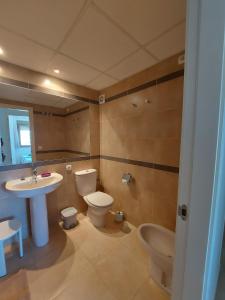 ein Badezimmer mit einem Waschbecken, einem WC und einem Waschbecken in der Unterkunft Rocasol - Suites in Calpe