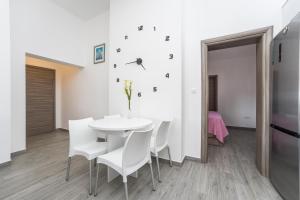 una sala da pranzo bianca con tavolo bianco e sedie bianche di Apartments Maza a Zara (Zadar)