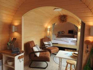 een kamer met een slaapkamer met een bed en stoelen bij De Hut, in Natuurgebied en vlakbij het Strand in Callantsoog