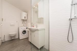 a bathroom with a sink and a washing machine at Apartments Maza in Zadar