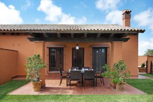 un patio con mesa y sillas frente a una casa en Villa Marta Clara 2, en Conil de la Frontera