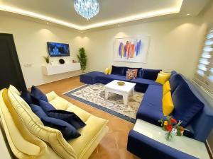 sala de estar con sofá azul y almohadas amarillas en ☆ Luxury Al-Amir House Martil ☆, en Martil