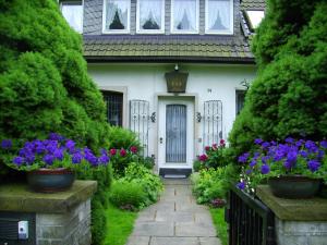 a white house with flowers in front of it at Gästehaus Villa Kreativ Susanne Lay in Bad Münder am Deister