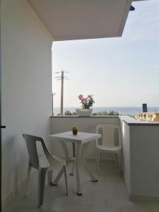 a table and chairs on a balcony with a view of the ocean at L'Alba in Tropea