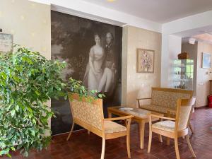 a living room with a table and chairs and a painting at Hotel Jurate in Nida
