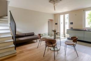 Parco Reala // Rural - Luxury - Rooms في Corneliano d'Alba: غرفة معيشة مع طاولة وكراسي زجاجية