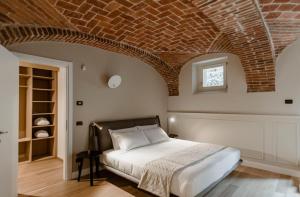 Parco Reala // Rural - Luxury - Rooms في Corneliano d'Alba: غرفة نوم بسرير من الطوب السقف