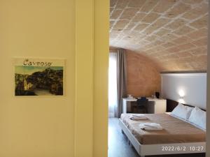 ein Schlafzimmer mit einem Bett in einem Zimmer in der Unterkunft In & Out Matera in Matera