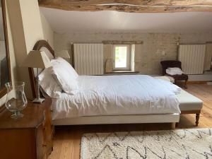a bedroom with a large white bed and a table at Chambres des Lunes in Aumagne +28 photos