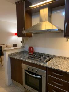 a kitchen with a stove top oven and a microwave at Departamento Quinta N in Mendoza