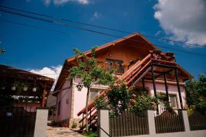 a house with a fence in front of it at Pensiunea Happy Flowers in Greci