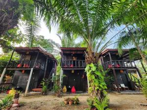 a group of houses with palm trees in front of them at Leaf House Bungalows in Ko Lanta