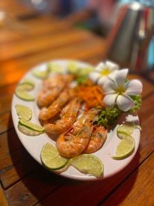 a plate of food with shrimp and vegetables on a table at Leaf House Bungalows SHA PLUS approved in Ko Lanta
