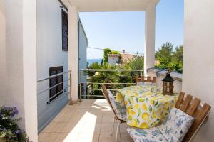 a table and chairs on the balcony of a house at Apartments Danica in Murter
