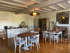a dining room with two wooden tables and chairs at Chambres des Lunes in Aumagne