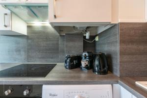 a kitchen counter with a stove and a microwave at Sunshine by Plaza - Proche Disneyland Paris in Montévrain