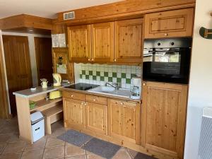 a kitchen with wooden cabinets and a sink and a microwave at M3 in Le Grand-Bornand