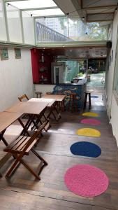 un patio con mesas, sillas y alfombras coloridas en Nomade In Arte e Hostel São Paulo, en São Paulo