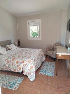 Un dormitorio con una cama y un escritorio y una ventana. en VILLA PROVIDENCIA, en Bitem 40 fotos más