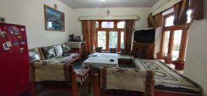 a living room with a couch and a table and chairs at Thangkop House in Leh