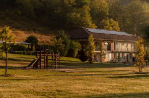 Parco Reala // Rural - Luxury - Rooms في Corneliano d'Alba: منزل فيه ملعب في حقل مع مبنى
