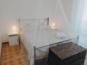 una camera con letto a baldacchino e 2 asciugamani bianchi di LIDO-VINTAGE Free Parking Wi-fi AC & Netflix a Lido di Camaiore