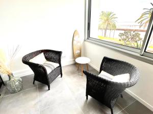 uma sala de estar com duas cadeiras e uma janela em Plage Landsberg Appartement 2 pièces en bord de mer em Saint-Laurent-du-Var