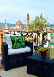 a black wicker chair with a pillow on a balcony at The View Of Sangiorgio in Florence