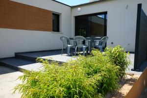 un patio con sedie e piante di fronte a un edificio di Maison contemporaine aux portes de Brest a Bohars
